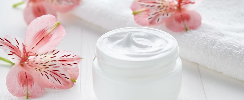 Yogurt cream natural organic beauty cosmetic product wellness and relaxation makeup mask in glass jar with pink flowers and towel on white background