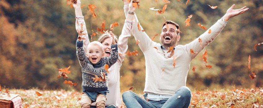 Picture of a happy family having fun in the autumn park.